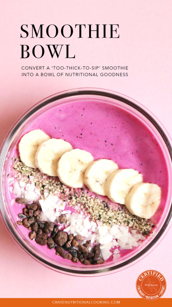 oats recipes - aerial view of pink smoothie bowl that contains rolled oats as an ingredient; slices of banana, seeds, coconut flakes, cacao chips arranged in neat rows on top