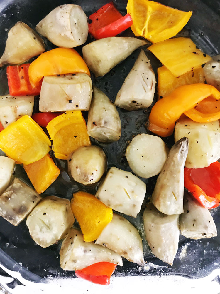 chunks of sweet yellow and red pepper, yellow sweet potatoes in a oven baking pan