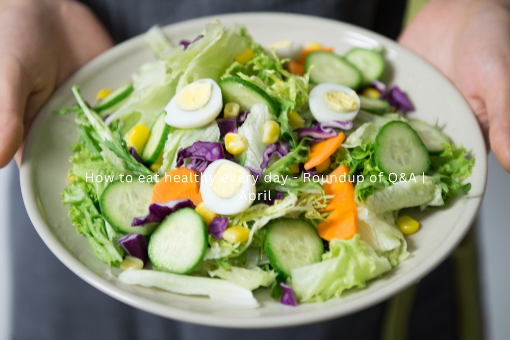 woman holding a large bowl of healthy egg and green salad ingredients
